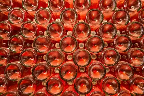 rosé champagne bottles stacked up and viewed from the bottom